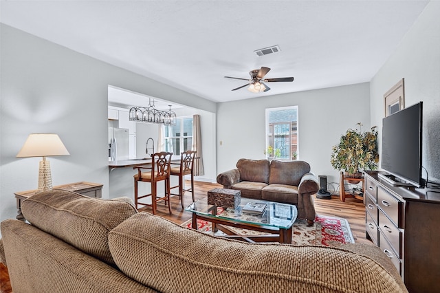 1326 W Bond St, Denison, TX 75020 - living room with light wood-style floors, ceiling fan, and a chandelier