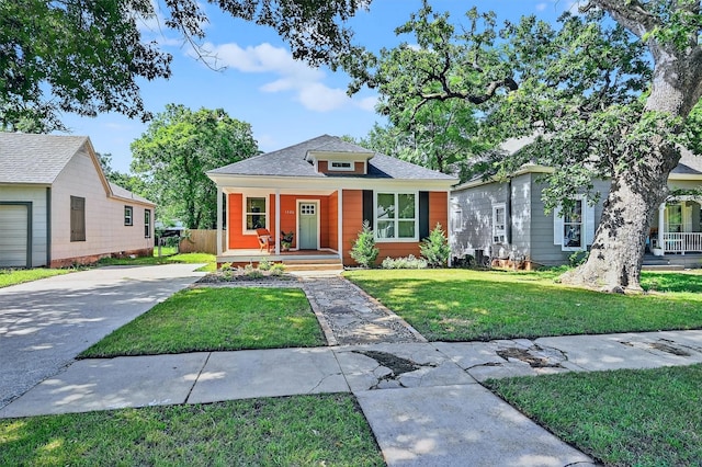 1326 W Bond St, Denison, TX 75020 - view of front of home with covered porch, a front lawn, driveway, and roof with shingles