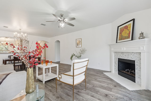 913 Lovebird Ln, Little Elm, TX 75068 - living room with arched walkways, wood finished floors, ceiling fan, a tile fireplace, and a chandelier