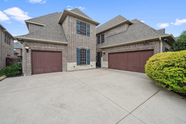 4652 Man O War Rd, Carrollton, TX 75010 - french country style house featuring brick siding, a shingled roof, an attached garage, and concrete driveway