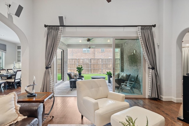 4652 Man O War Rd, Carrollton, TX 75010 - living area featuring arched walkways, a ceiling fan, wood finished floors, and a towering ceiling