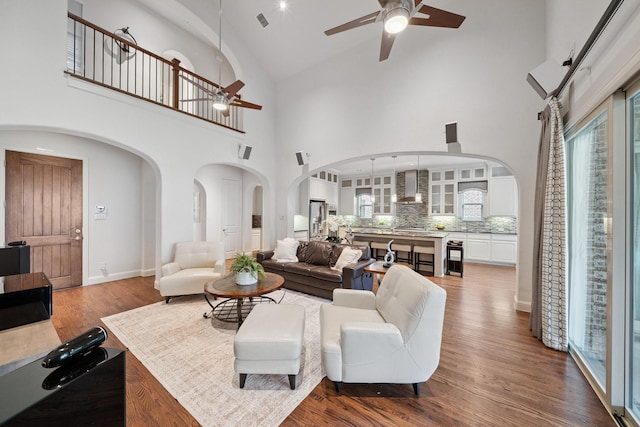4652 Man O War Rd, Carrollton, TX 75010 - living area featuring arched walkways, a ceiling fan, high vaulted ceiling, and wood finished floors
