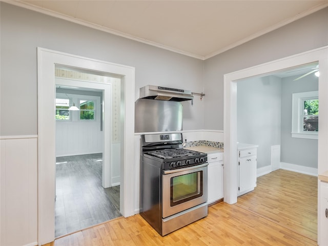 1114 W Congress St, Denton, TX 76201 - kitchen featuring stainless steel gas stove, ventilation hood, light wood-type flooring, white cabinetry, and ornamental molding