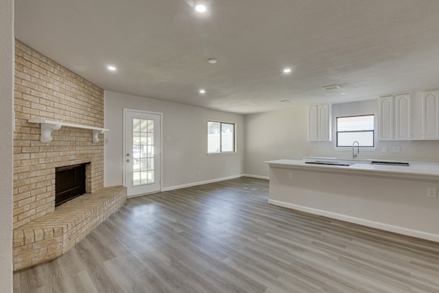 1006 Sleepy Hollow Dr, Garland, TX 75043 - unfurnished living room featuring light wood finished floors, a fireplace, and recessed lighting