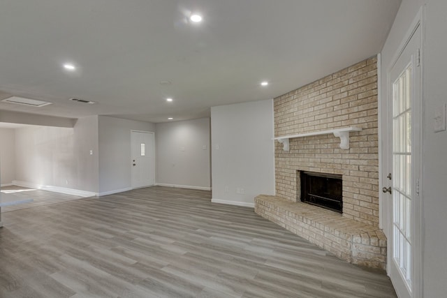 1006 Sleepy Hollow Dr, Garland, TX 75043 - unfurnished living room with wood finished floors, recessed lighting, and a brick fireplace