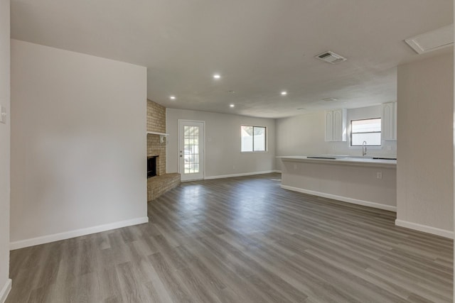 1006 Sleepy Hollow Dr, Garland, TX 75043 - unfurnished living room featuring wood finished floors, recessed lighting, and a fireplace