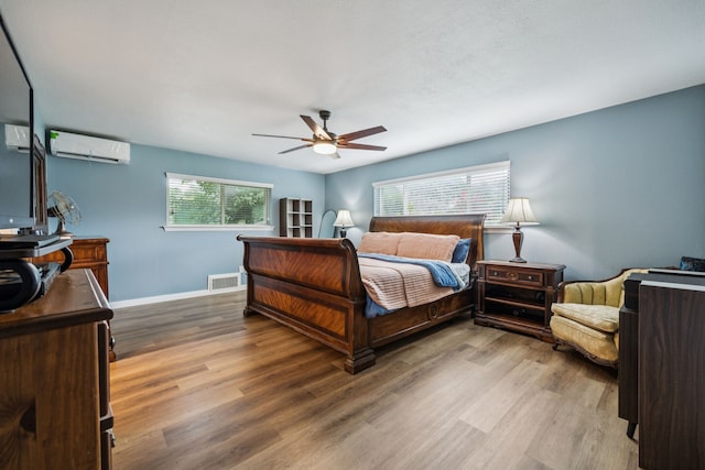 1509 Bar Harbor Dr, Dallas, TX 75232 - bedroom featuring a wall mounted air conditioner, wood finished floors, and a ceiling fan