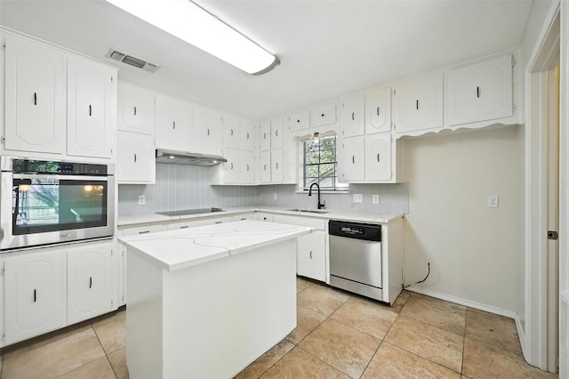 8109 Starnes Rd, North Richland Hills, TX 76182 - kitchen with appliances with stainless steel finishes, backsplash, under cabinet range hood, white cabinetry, and a kitchen island