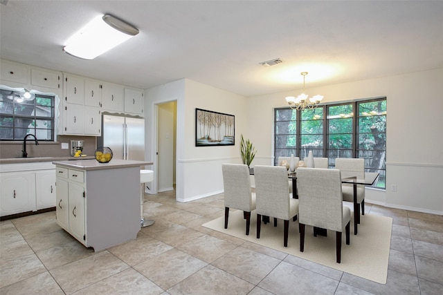 8109 Starnes Rd, North Richland Hills, TX 76182 - kitchen with a chandelier, stainless steel fridge, light countertops, white cabinets, and a kitchen island