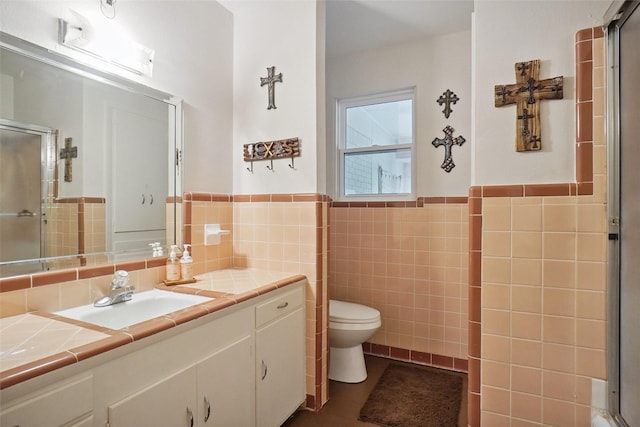 201 N Frederick St, Ponder, TX 76259 - bathroom with tile walls, vanity, a shower with door, and a wainscoted wall