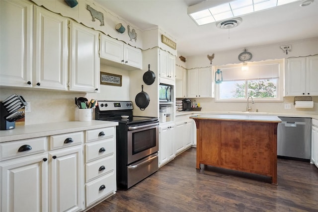 201 N Frederick St, Ponder, TX 76259 - kitchen with appliances with stainless steel finishes, light countertops, dark wood finished floors, and white cabinets