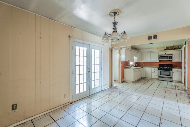 4608 Sandra Lynn Dr, Mesquite, TX 75150 - kitchen featuring appliances with stainless steel finishes, a chandelier, french doors, light tile patterned flooring, and white cabinetry