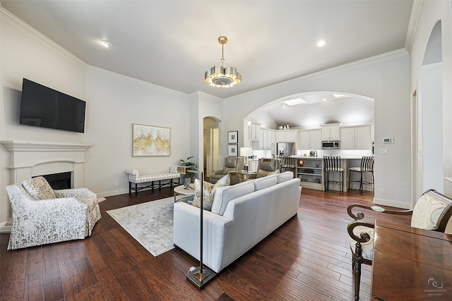 1682 Morris Ln, Frisco, TX 75034 - living area featuring arched walkways, dark wood-style flooring, ornamental molding, a fireplace, and recessed lighting