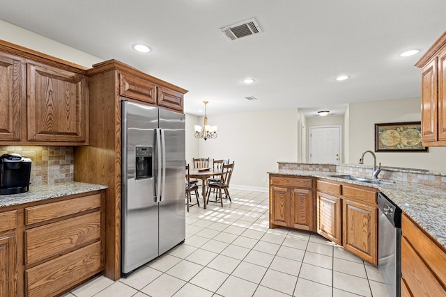 102 Southfork Cir, Pottsboro, TX 75076 - kitchen featuring appliances with stainless steel finishes, recessed lighting, brown cabinets, light tile patterned floors, and backsplash