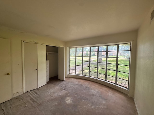 817 Brook Valley Ln, Dallas, TX 75232 - unfurnished bedroom featuring multiple windows, a closet, and concrete flooring
