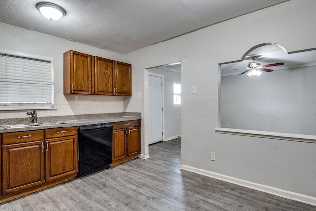 4137 Salem Dr, Garland, TX 75043 - kitchen featuring dishwasher, light wood-type flooring, ceiling fan, brown cabinets, and a textured ceiling