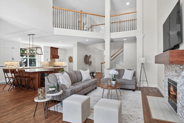 1709 Blair Ct, Carrollton, TX 75010 - living room with wood finished floors, a fireplace, a high ceiling, wine cooler, and stairway