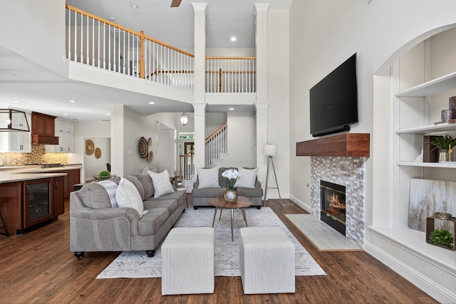 1709 Blair Ct, Carrollton, TX 75010 - living area with beverage cooler, dark wood-style floors, decorative columns, and a high ceiling