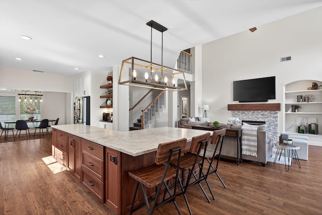 1709 Blair Ct, Carrollton, TX 75010 - kitchen featuring freestanding refrigerator, a chandelier, dark wood-style floors, a breakfast bar area, and recessed lighting