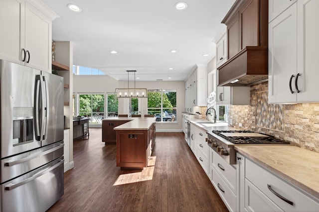 1709 Blair Ct, Carrollton, TX 75010 - kitchen featuring appliances with stainless steel finishes, a kitchen island, light countertops, dark wood-style flooring, and tasteful backsplash