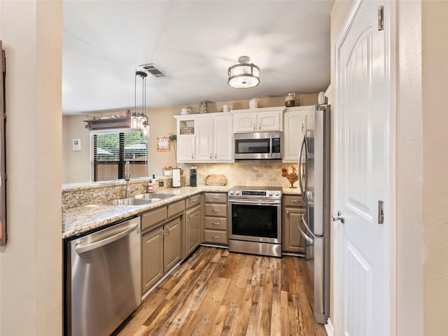 153 Bridlepath Dr, Pottsboro, TX 75076 - kitchen featuring stainless steel appliances, light wood-style floors, white cabinetry, backsplash, and gray cabinetry