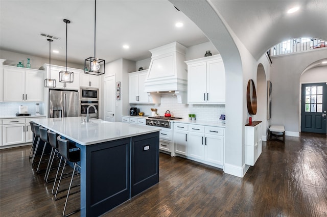 840 Redstem Dr, Prosper, TX 75078 - kitchen featuring stainless steel appliances, a breakfast bar, decorative backsplash, light countertops, and dark wood-style floors