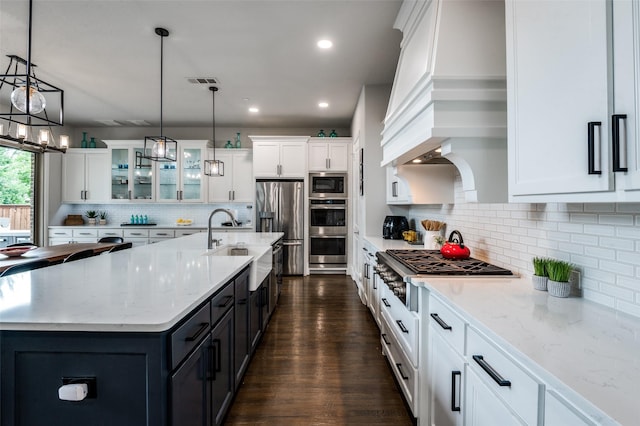 840 Redstem Dr, Prosper, TX 75078 - kitchen with appliances with stainless steel finishes, white cabinetry, glass insert cabinets, tasteful backsplash, and dark wood-style floors
