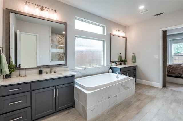 840 Redstem Dr, Prosper, TX 75078 - ensuite bathroom with two vanities, a bath, wood finished floors, and tiled shower