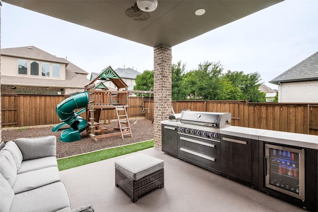 840 Redstem Dr, Prosper, TX 75078 - fenced backyard with beverage cooler, a playground, exterior kitchen, and a patio area