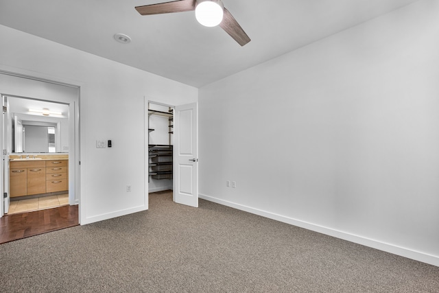 1200 Main St Unit 707, Dallas, TX 75202 - unfurnished bedroom featuring dark colored carpet, a closet, ensuite bathroom, a ceiling fan, and a walk in closet