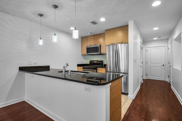 1200 Main St Unit 707, Dallas, TX 75202 - kitchen with stainless steel appliances, a peninsula, dark countertops, dark wood finished floors, and recessed lighting