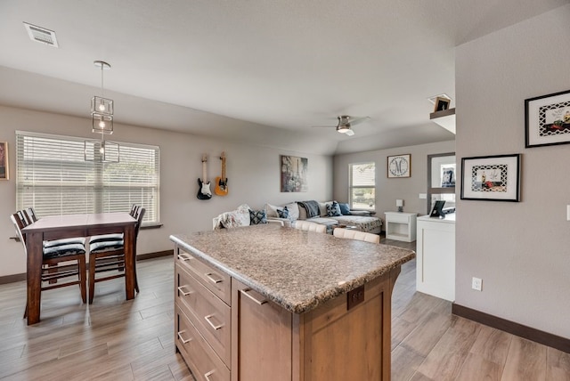 421 W Holford St, Pilot Point, TX 76258 - kitchen with a ceiling fan, light wood-type flooring, a kitchen island, and light countertops