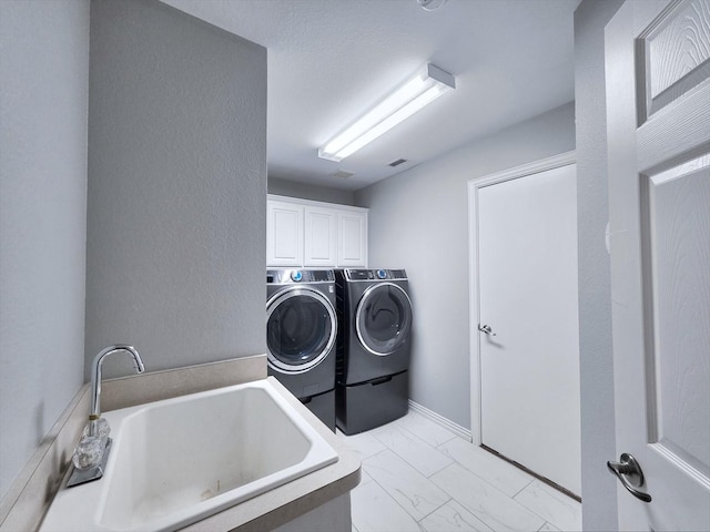 4348 Rice Ln, Carrollton, TX 75010 - laundry room with washer and clothes dryer, cabinet space, and light marble finish flooring