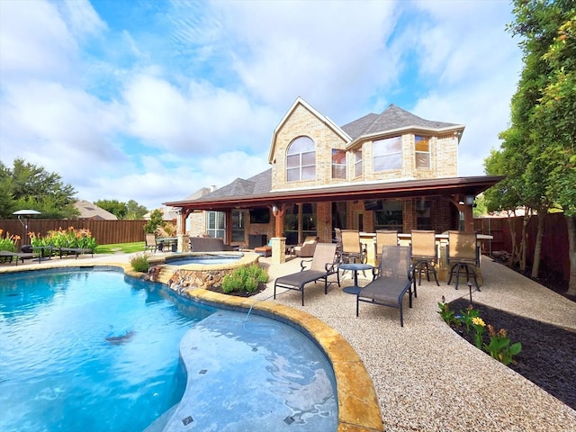 4348 Rice Ln, Carrollton, TX 75010 - back of house featuring a fenced backyard, stone siding, a patio area, and a pool with connected hot tub