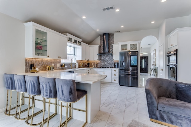 1400 Ambrose Dr, Allen, TX 75002 - kitchen featuring stainless steel appliances, wall chimney range hood, a peninsula, a kitchen breakfast bar, and lofted ceiling