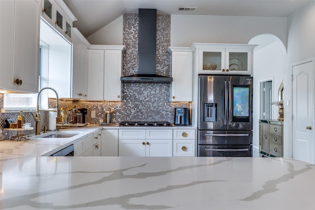 1400 Ambrose Dr, Allen, TX 75002 - kitchen with stainless steel fridge with ice dispenser, wall chimney exhaust hood, white cabinets, tasteful backsplash, and lofted ceiling