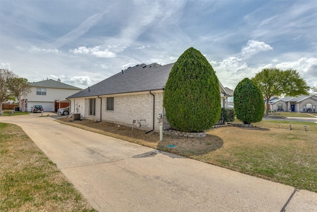 1400 Ambrose Dr, Allen, TX 75002 - view of side of property featuring concrete driveway, brick siding, a shingled roof, and a yard