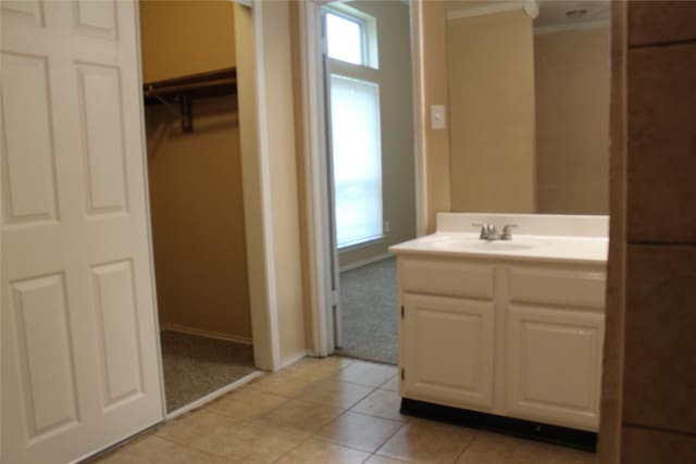 1108 Paintbrush St, Mesquite, TX 75149 - bathroom with vanity, ornamental molding, tile patterned flooring, and a walk in closet