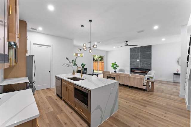 2828 Rochester St, Dallas, TX 75215 - kitchen with stainless steel appliances, ceiling fan, recessed lighting, an island with sink, and a high end fireplace