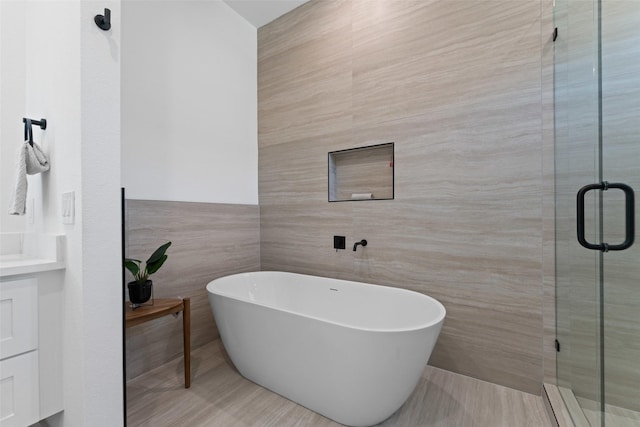 2828 Rochester St, Dallas, TX 75215 - bathroom with tile walls, a freestanding tub, and a stall shower