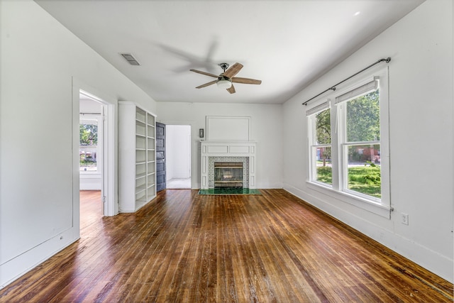 1143 W Jones St, Stephenville, TX 76401 - unfurnished living room featuring ceiling fan, wood-type flooring, and a tiled fireplace