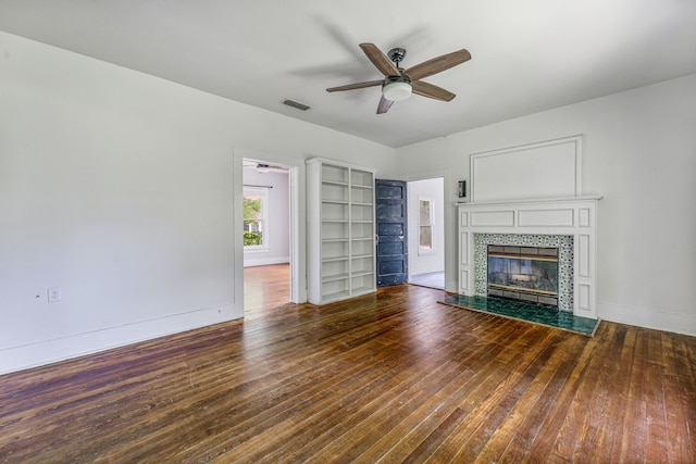 1143 W Jones St, Stephenville, TX 76401 - unfurnished living room featuring ceiling fan, wood-type flooring, and a tile fireplace