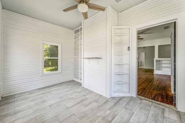 1143 W Jones St, Stephenville, TX 76401 - unfurnished room with a ceiling fan, wood finished floors, and built in shelves