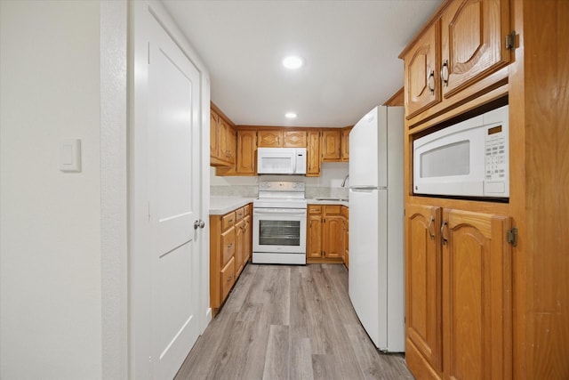 416 W 3rd St, Justin, TX 76247 - kitchen with white appliances, light countertops, light wood finished floors, brown cabinets, and recessed lighting