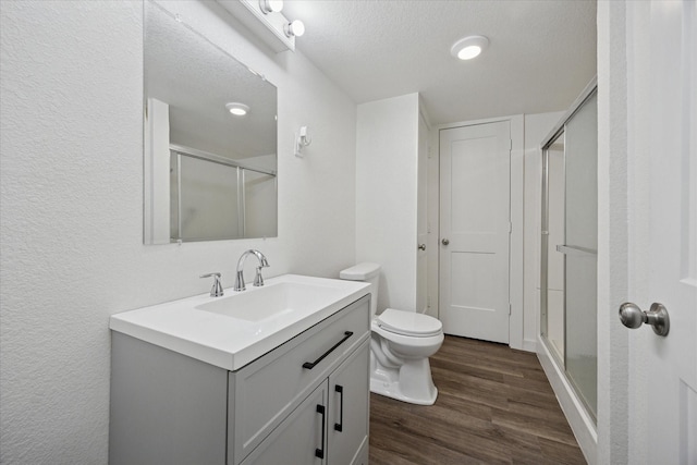 416 W 3rd St, Justin, TX 76247 - bathroom featuring a shower stall, vanity, wood finished floors, a textured ceiling, and a textured wall