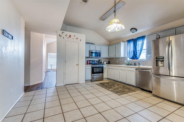 1008 Brook Cyn, Arlington, TX 76018 - kitchen with appliances with stainless steel finishes, light countertops, lofted ceiling, tasteful backsplash, and pendant lighting