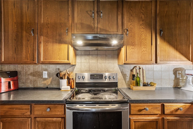9507 Tallow Berry Dr, Dallas, TX 75249 - kitchen with stainless steel range with electric stovetop, ventilation hood, dark countertops, and tasteful backsplash