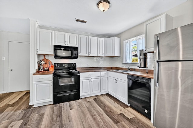 1031 Patricia Dr, Sherman, TX 75090 - kitchen with black appliances, wooden counters, white cabinets, and light wood finished floors