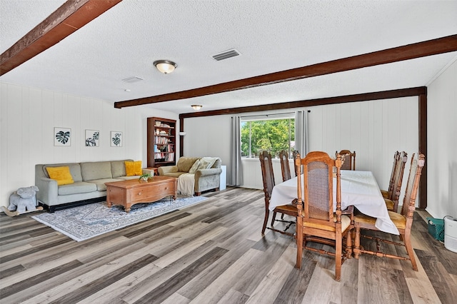 1031 Patricia Dr, Sherman, TX 75090 - dining room featuring beam ceiling, wood finished floors, a textured ceiling, and wood walls