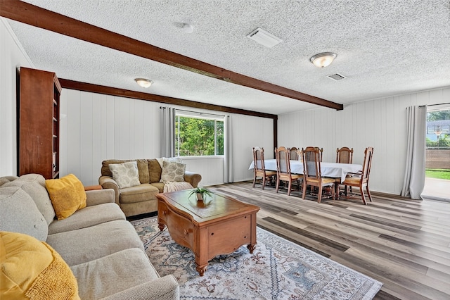1031 Patricia Dr, Sherman, TX 75090 - living area featuring wood finished floors, beam ceiling, a textured ceiling, and wood walls